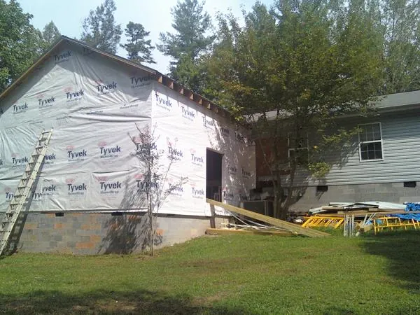 Tyvek wrapped gable on a new room addition beside an existing home in Emerson
