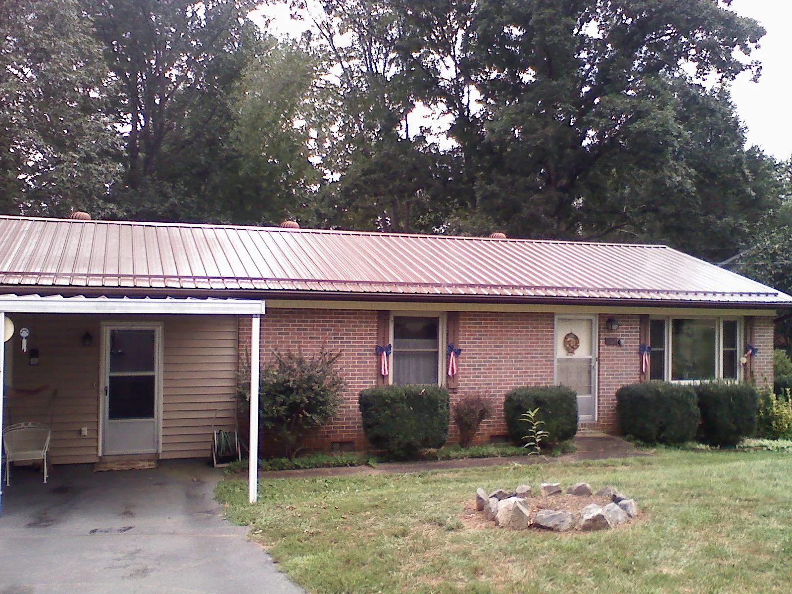 Bronze metal roof and carport on a brick ranch home — Roof Repair work by our crew in Emerson